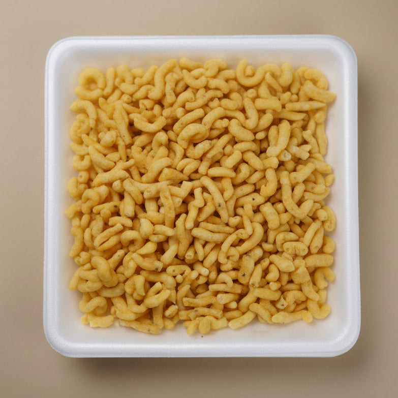 Square white container filled with Bareek Gathiya crafted by Bombay Nimco